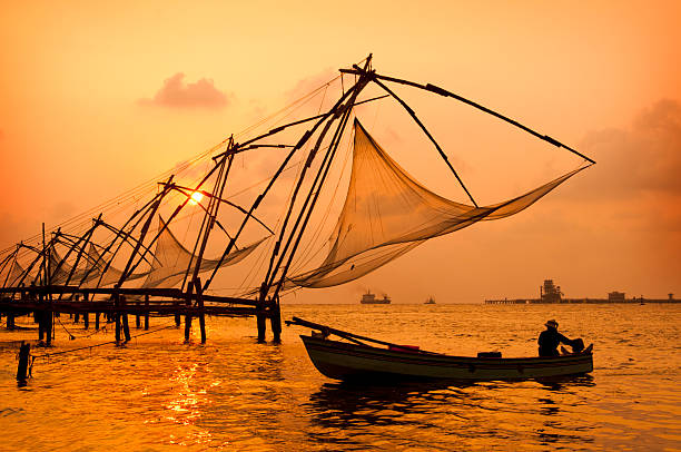 Sunset over Chinese Fishing nets and boat in Cochin (Kochi), Kerala, India.Sunset over Chinese Fishing nets and boat in Cochin (Kochi), Kerala, India.Sunset over Chinese Fishing nets and boat in Cochin (Kochi), Kerala, India.